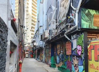 Narrow laneway with colourful graffiti images on walls
